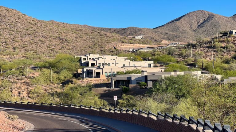 Arizona hillside homes along curving desert road representing home equity investment qualification requirements