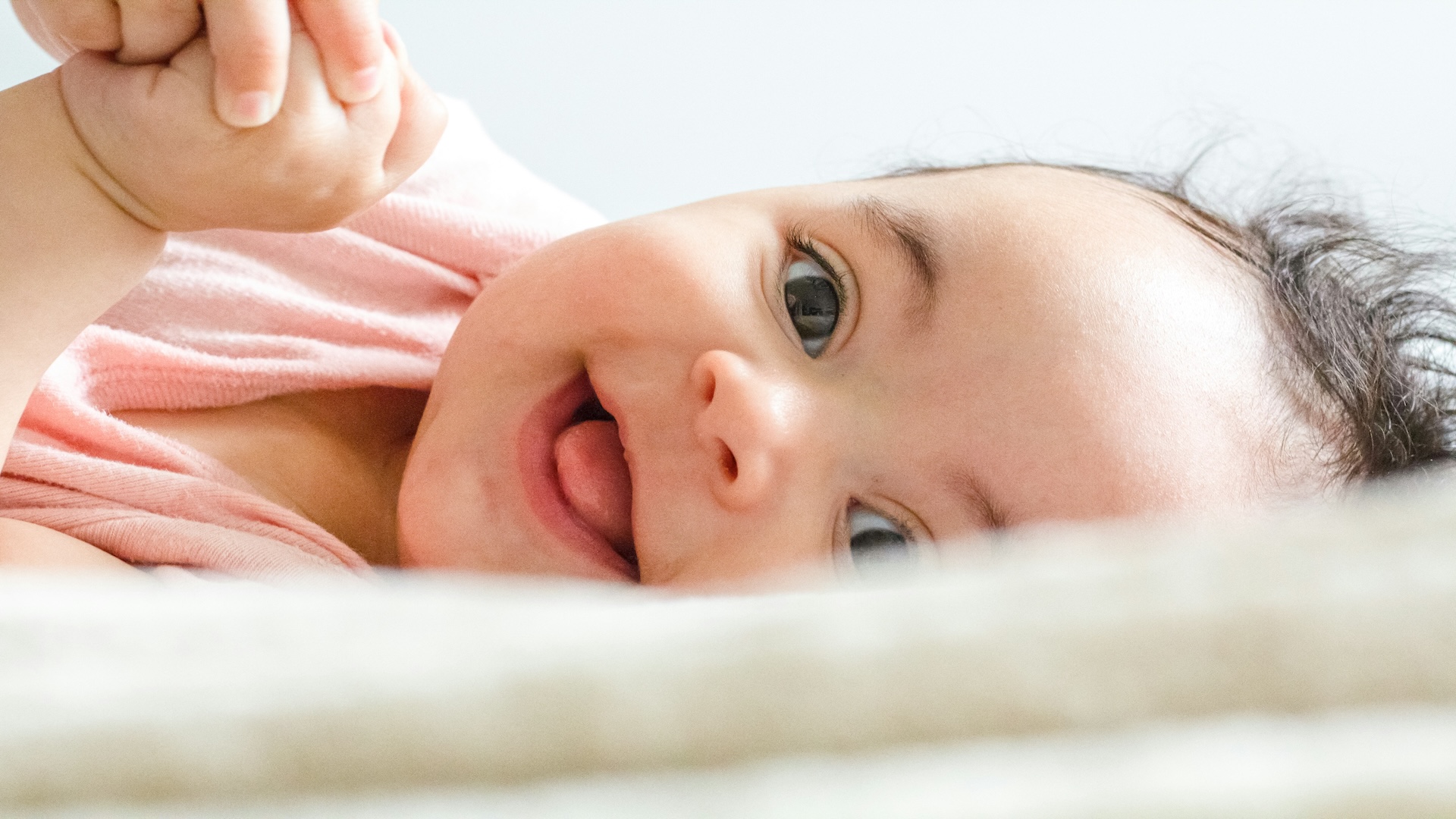 Peaceful newborn infant sleeping on a neutral-colored blanket, representing the successful outcome of an IVF journey.